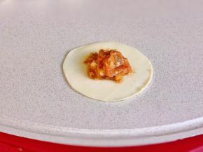 取一张饺子皮，放上肉馅，按自己习惯包起来即可。