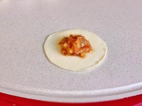 取一张饺子皮，放上肉馅，按自己习惯包起来即可。