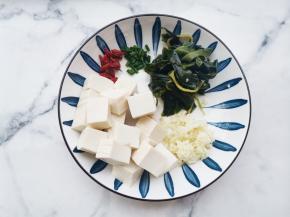 裙带菜提前十分钟泡发洗净切段。豆腐切小块。