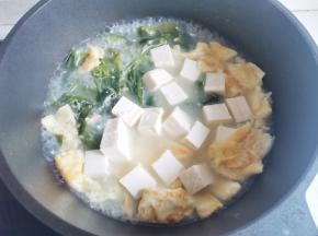 汤汁变白后倒入裙带菜和豆腐块，中火煮6-8分钟。