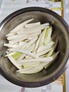 切好的萝卜条放入盆中，放入7勺盐，揉搓均匀，腌制两个小时！