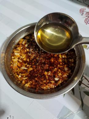 把热油浇在混合好的辣椒上，边浇边搅拌，以免辣椒糊了！