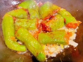 另起锅倒入底油加热放入葱姜蒜爆香再放入尖椒酿肉