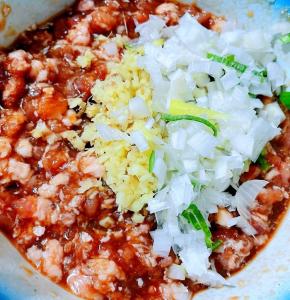 新鲜的猪肉馅分两次打入少量水搅拌均匀这样肉馅口感更嫩放入调味料一品鲜酱油、蚝油、糖、料酒、黑胡椒粉葱、姜搅拌均匀