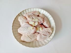 鸡翅放入盘中加蒜。
