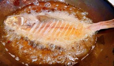 偏口鱼的两侧割几刀别割断放入加热的油锅中大火炸起来