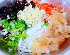 泡发好的木耳开水焯一下后立即放人冷水中过凉再沥干水分切丝香菜洗净切成小段蒜剁成蒜粒胡萝卜去皮洗净切成丝和蜇皮、白菜一起放入容器中