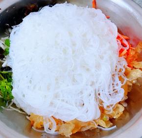 浸泡好的粉丝软硬适中在冷水中过一下沥干水分剪几刀放入容器中