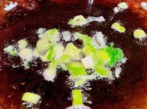 另起锅倒入少许底油加热放入香葱爆香