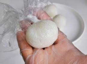 用保鲜膜裹住米饭，捏成小圆球。