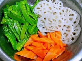 处理好的藕片、荷兰豆切好的胡萝卜片放入容器中备用