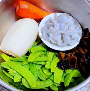 准备原材料新鲜的虾仁，荷兰豆去掉两端筋洗净、莲藕去皮洗净、木耳泡发好在开水中焯水后立即放入冷水中过凉沥干水分