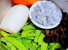 准备原材料新鲜的虾仁，荷兰豆去掉两端筋洗净、莲藕去皮洗净、木耳泡发好在开水中焯水后立即放入冷水中过凉沥干水分