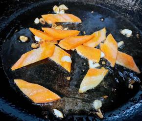 锅中倒入底油加热放入蒜粒爆香再放入胡萝卜炒至断生