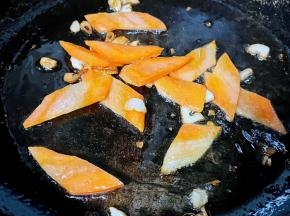 锅中倒入底油加热放入蒜粒爆香再放入胡萝卜炒至断生