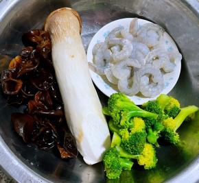 准备原材料杏鲍菇、新鲜的虾仁、泡发好的木耳开水焯一下后立即放入冷水中过凉沥干水分西兰花掰成小朵放入开水中放一点点盐再放入西兰花焯水变色立即放入冷水中过凉再沥干水分