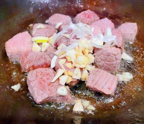 炒至牛肉变色放入葱姜蒜爆香