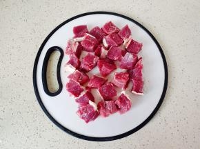 把牛肉切成小方块。
