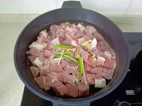 浸泡好的牛肉冷水下锅，加入葱段，生姜片。