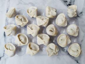 取适量肉馅包入饺子皮中，全部做好。