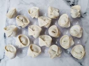 取适量肉馅包入饺子皮中，全部做好。