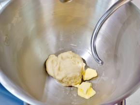 取一块面团可以拉出厚膜时加入软化好的黄油。