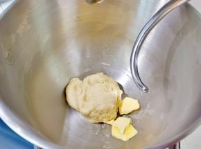 取一块面团可以拉出厚膜时加入软化好的黄油。