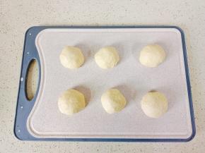 发酵好的面团充分排气，分成六个小面团，盖保鲜膜醒发15分钟。