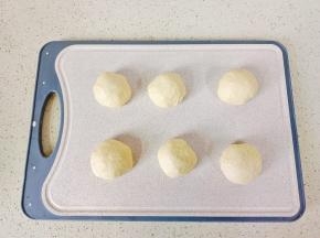 发酵好的面团充分排气，分成六个小面团，盖保鲜膜醒发15分钟。