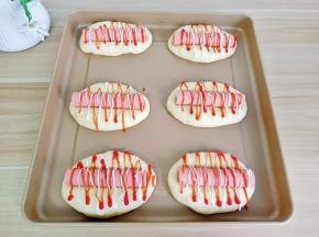 发酵好的面团中间放入一个火腿肠，挤上沙拉酱与番茄酱。