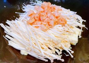 煎好的豆腐上面摆上金针菇和虾仁