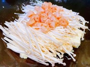 煎好的豆腐上面摆上金针菇和虾仁
