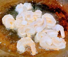 锅中倒入油加热放入虾仁中火煎