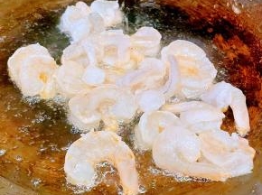 锅中倒入油加热放入虾仁中火煎