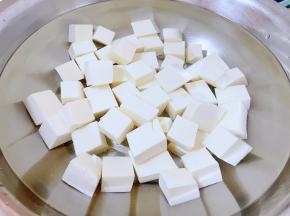 嫩豆腐切成大小均匀的小块状放入开水中烫一下后立即放入冷水中过凉备用