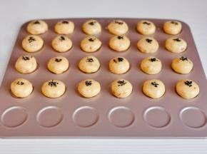 每个杏仁酥刷上蛋液，撒上黑芝麻。