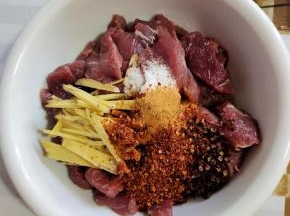碗中放入姜丝，一大勺料酒，一勺盐，两勺五香粉，三勺辣椒粉，一小把花椒！（喜欢吃辣的就多放一些辣椒粉！不喜欢吃辣的也可以不放辣椒粉，做成五香口味的也很好吃！）