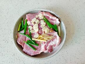把肉擦干水份，加葱姜蒜。