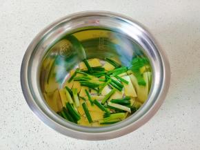 压力锅内胆铺上一层姜片与葱段。