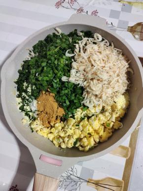 把韭菜放入鸡蛋碎中，放入一大把虾皮，两勺麻辣鲜，少许盐，少许胡椒粉，适量鸡精搅拌均匀！