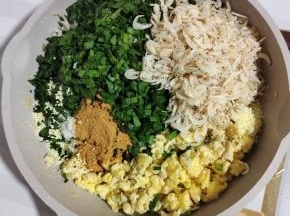 把韭菜放入鸡蛋碎中，放入一大把虾皮，两勺麻辣鲜，少许盐，少许胡椒粉，适量鸡精搅拌均匀！