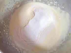 分两次筛入低筋面粉， 用刮刀从底部翻拌均匀，再进行下一次筛入。