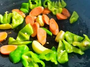 起锅热油，爆香大蒜，加入青椒火腿炒香，