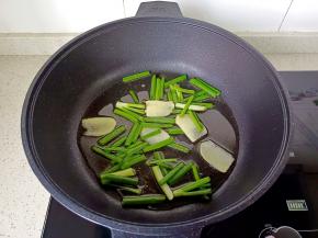 热锅凉油放葱段、姜片小火煎。