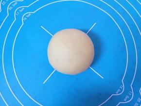 收口朝下摆放，用手掌轻轻压一下，一个紫薯果仁馅喜饼就包好了。 