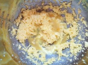 黄油用电动打蛋器打发至蓬松状态，分两次加入蛋液搅打均匀。 