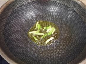 炒锅内倒适量的菜籽油烧热，下入葱段炒香。