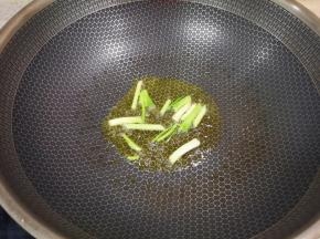 炒锅内倒适量的菜籽油烧热，下入葱段炒香。