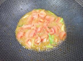下入西红柿翻炒至出汁。