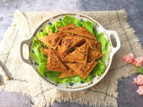 盘子里铺上生菜叶，放上煎好的孜然豆干。